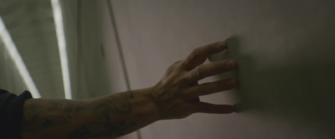 Man runs his hand against concrete wall