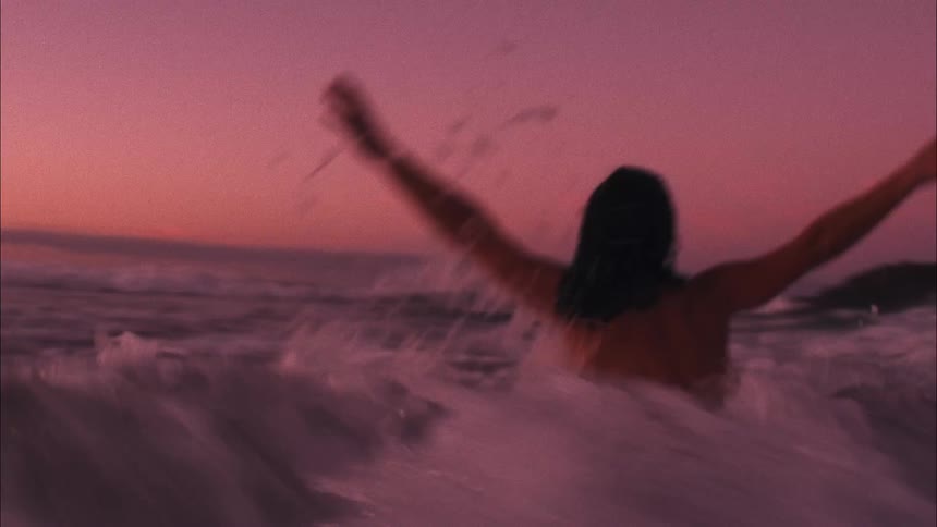 A woman swims against the waves