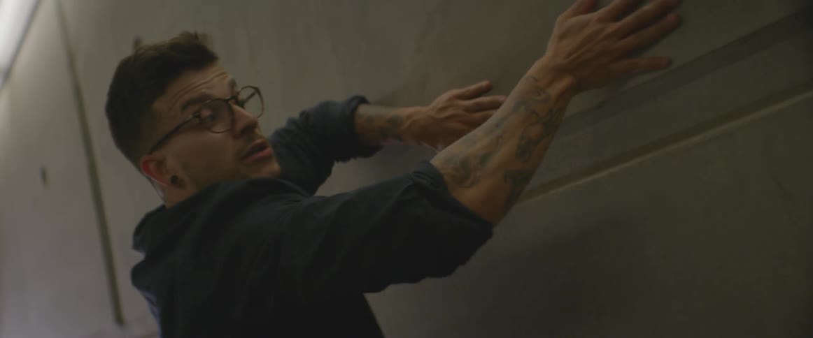 A man is using a wall as a prop as he does a dance performance