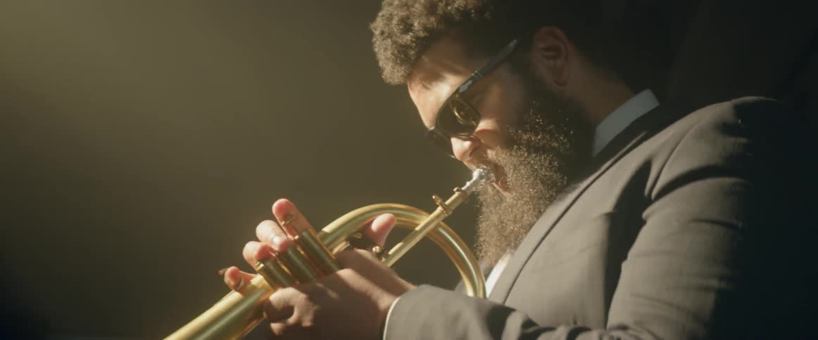 A man is playing a musical instrument wearing sunglasses