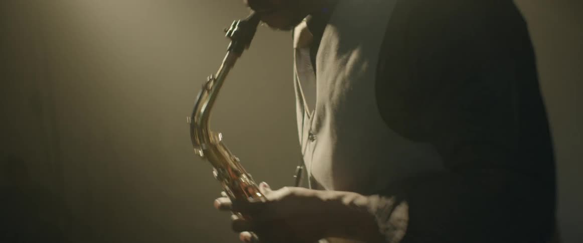 A man is energetically playing the saxophone