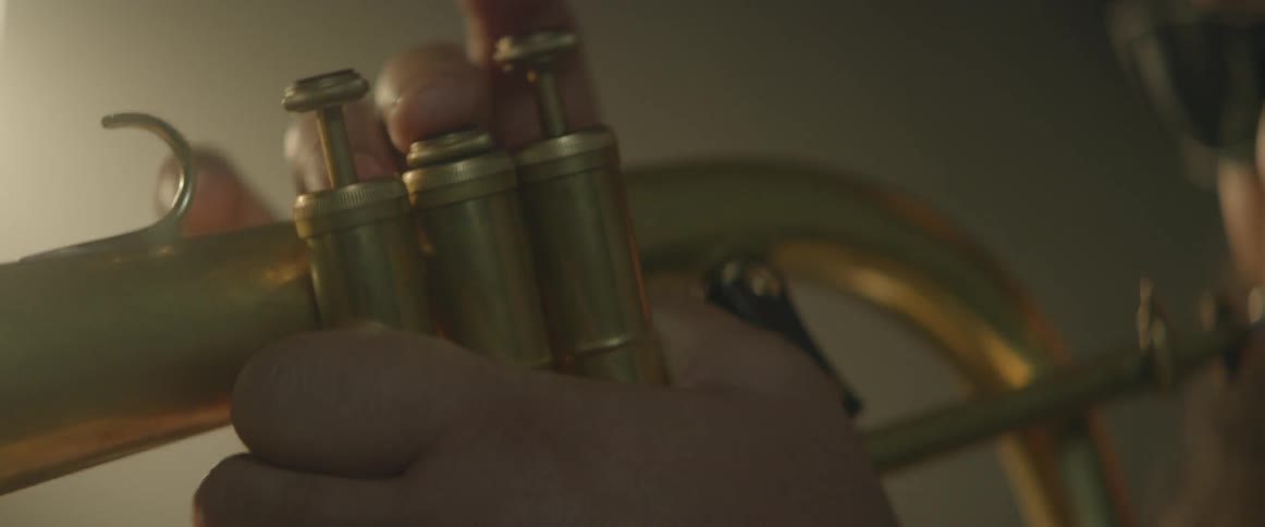 A person hit the keys of a brass instrument