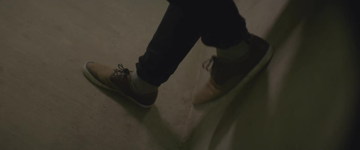 A man taps his foot against the wall