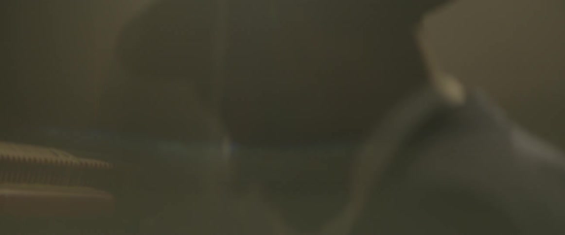 A black man in dark glasses and a hat sways forward