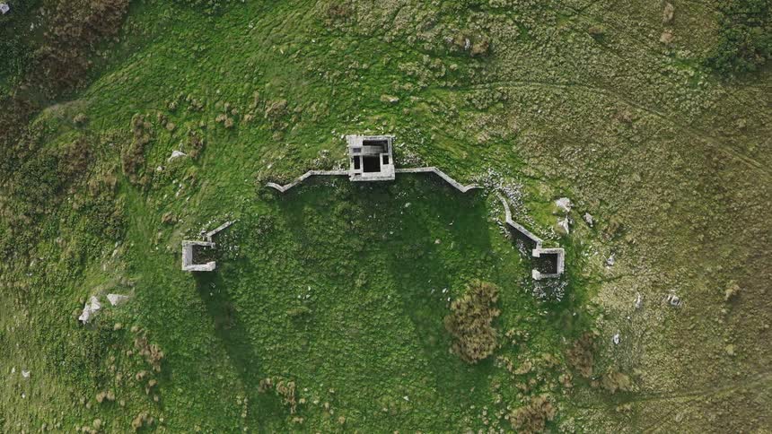 An aerial view of a castle ruin on a plain grassland
