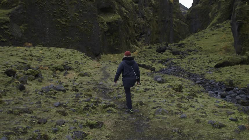 A person is hiking towards the mountain