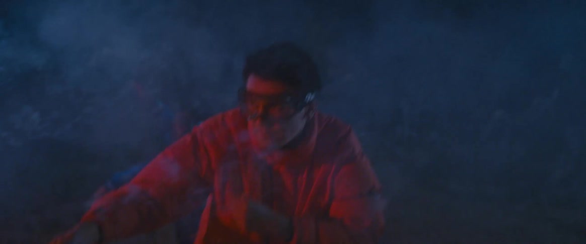 A man with protective glasses is pointing a stick and it is shooting colorful fireworks