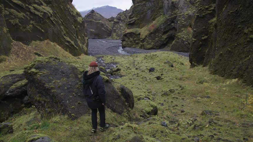 Woman walking among the ruins under the mountains