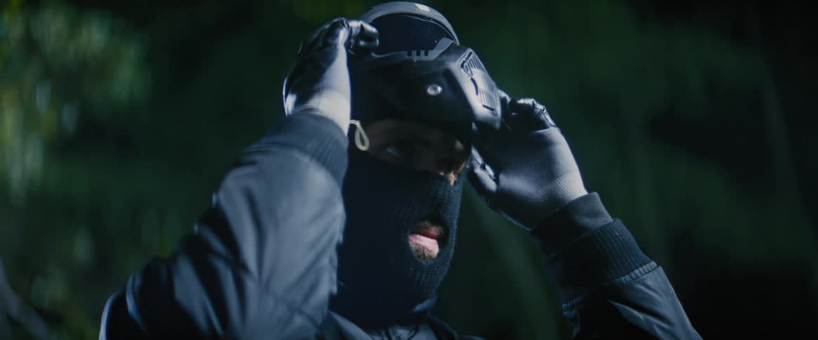 Man putting on protective glasses on his face in an outdoor setting at night