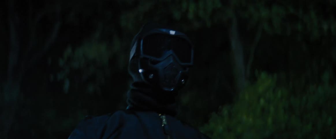 A dark fullface helmet with a reflective visor in a dark outdoor setting