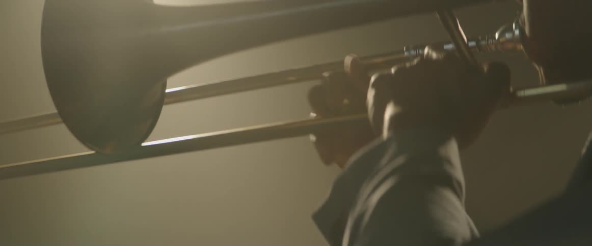 Man playing the trumpet in dark room