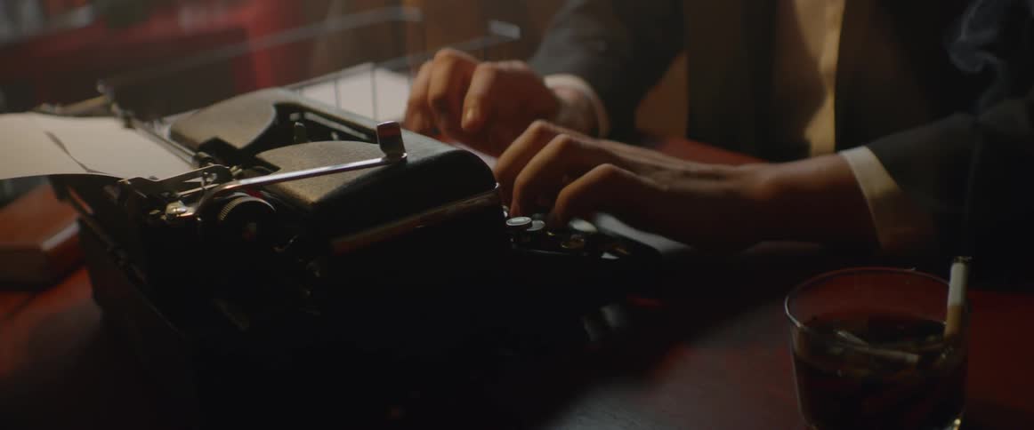 A man types at a typewriter