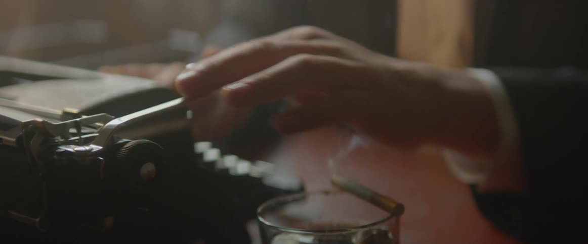 Man pushes lever of a typewriter and proceeds to type