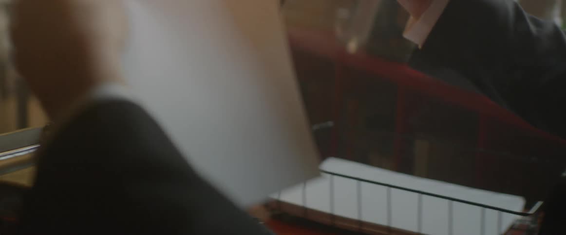A man is placing a new stack of paper in a typewriter