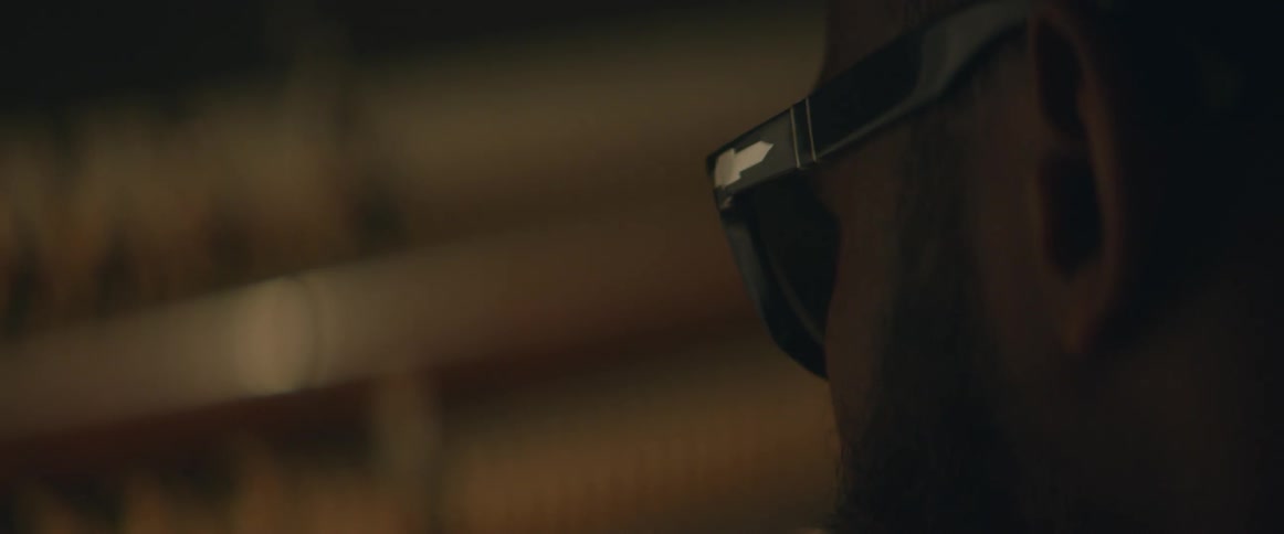 A man wearing sunglasses is bobbing his head