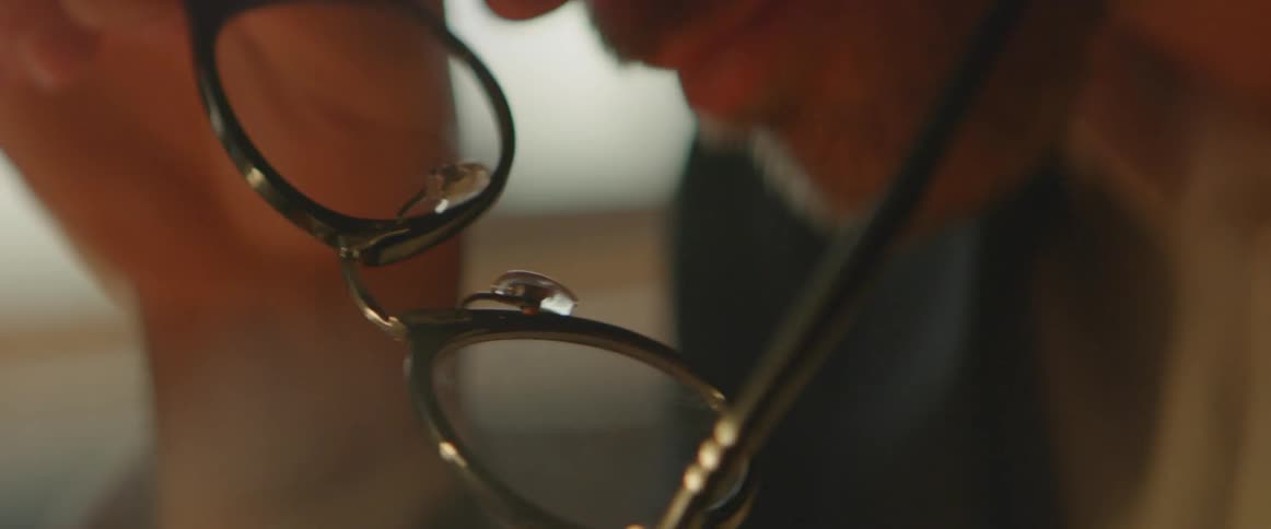 A man takes off his glasses while he thinks