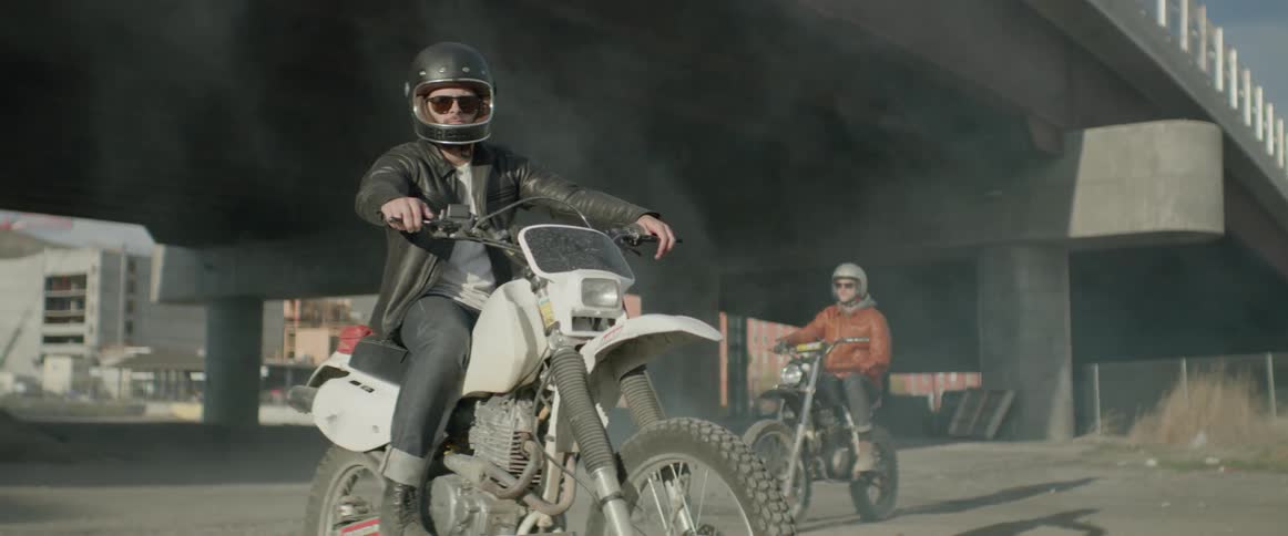 Men are sitting on stationary motorcycles