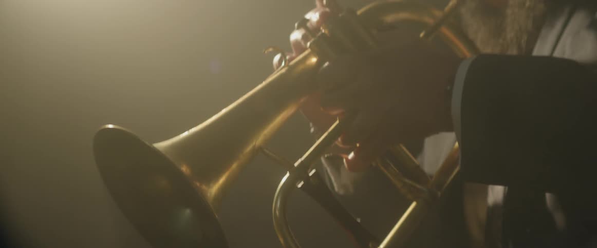 A man is playing a musical instrument under a spotlight