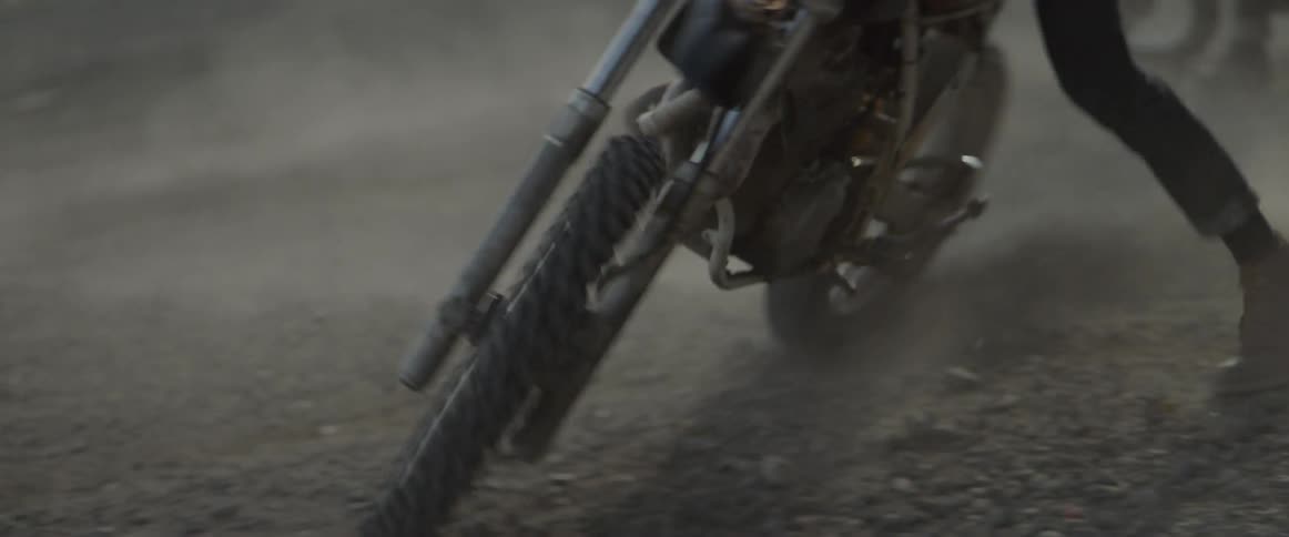 A man spins around in the dirt on a dirt bike