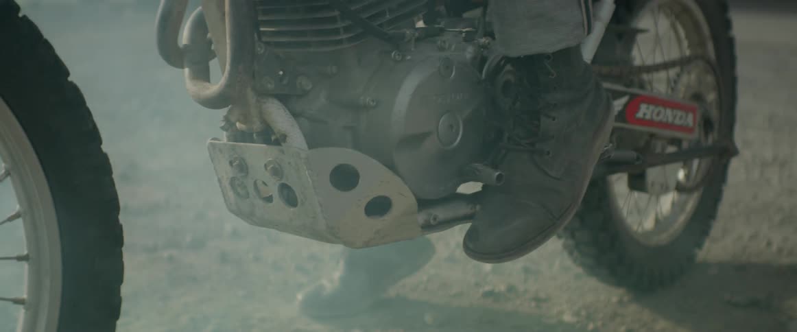 A motorcyclist revs his engine as smoke fills the air