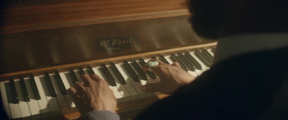 A man plays the keys of a piano