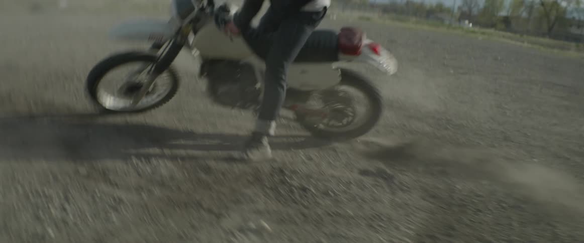 A person spinning up rocks on a motorbike