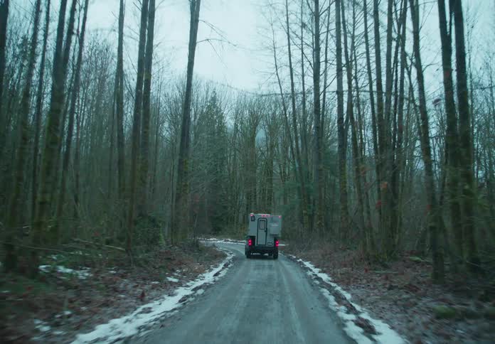 A truck driving along a snowy forest road