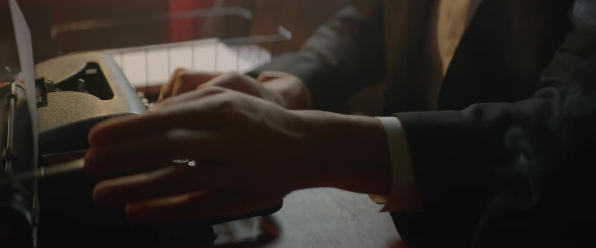 A man is typing on a typewriter