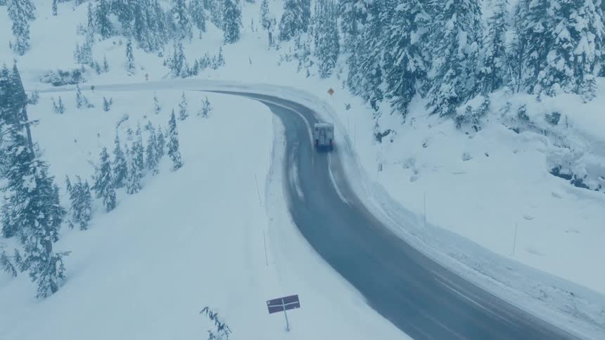 A van driving on a freeway on a snowy day