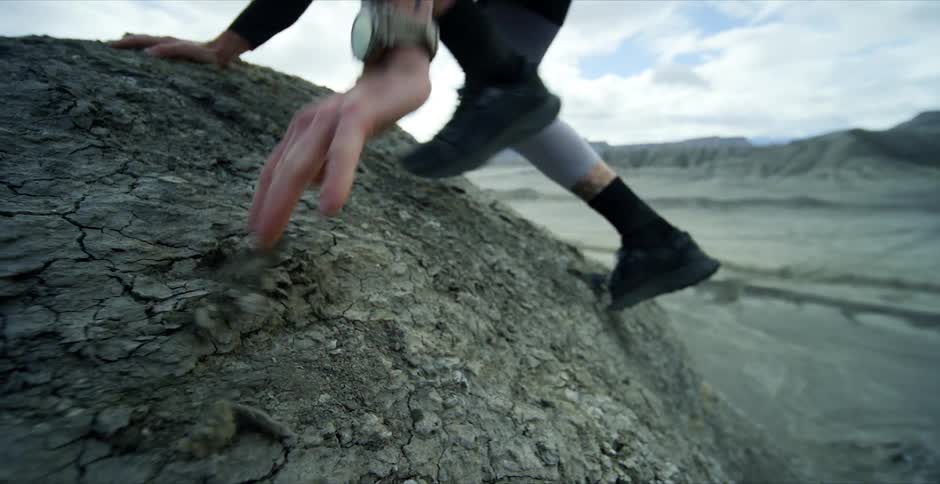 A man jumps over a mound of rocks
