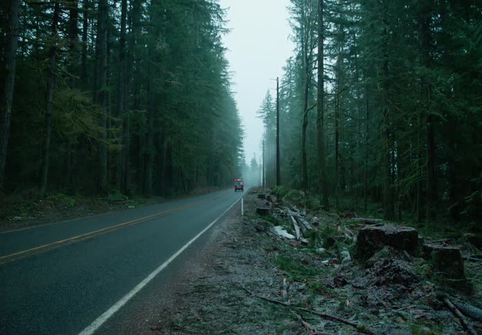 Trucks drive on the road as it rains