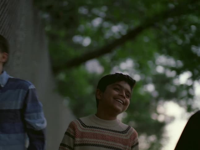 Three boys talking and laughing as they walk together