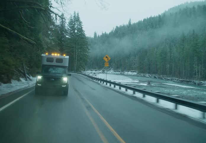 An suv car driving on a road near trees and in fog and snow