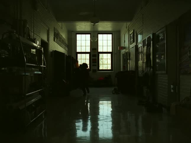 Children exit their classes then put on their coats running down the hall