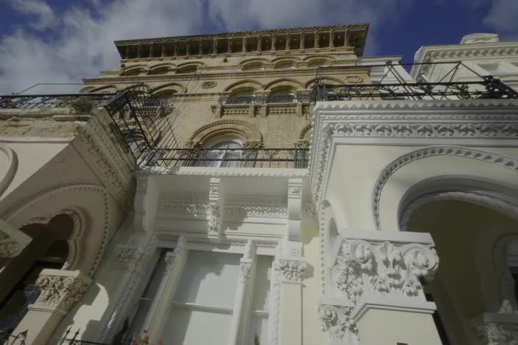 An ornate white building with intricate decorations and the address 56