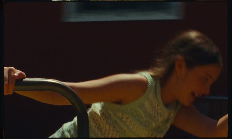 Girl runs while spinning a merry go round in the park