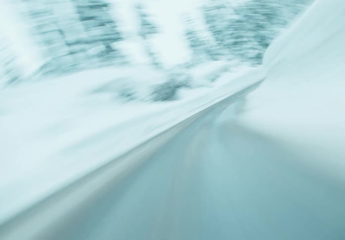 A snowcovered forest road in the forest during winter