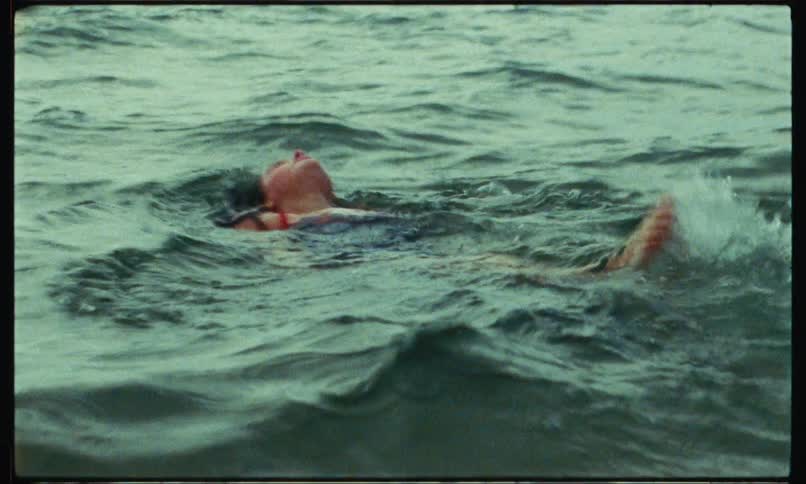 A woman is swimming backwards in the water