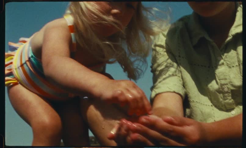 Mother with water in her hands and her little daughter placing her hands in the water