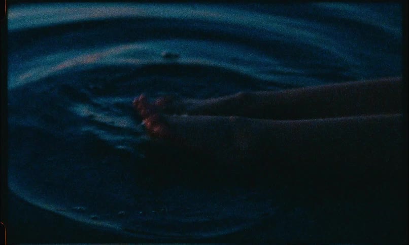 Two feet of a person hitting the surface of the water and making ripples