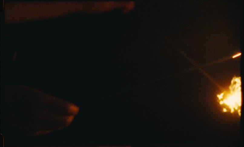 A person holding two rods with the ends giving off bright sparks on a night