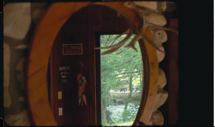 A clip of a mirror in a room reflecting a nearby river