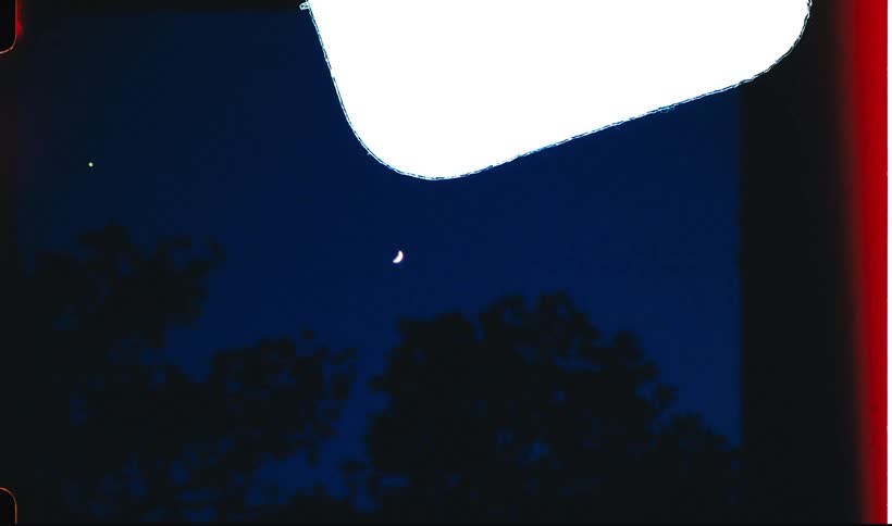 The moon in the night sky and several red beams passing on the screen
