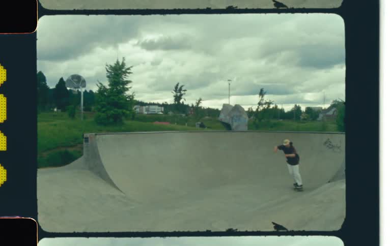 Young man skateboarding in a skatepark on a cloudy day