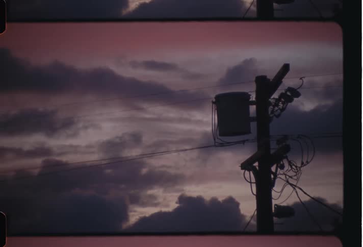 Silhouette of electric lines at sunset caught on vintage film