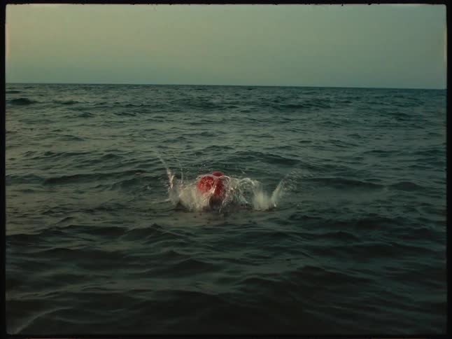 A little girl is in the sea and takes a dive below