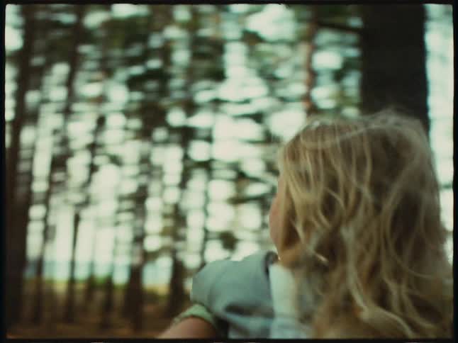 Girl is carrying her little sister on their back in a forest