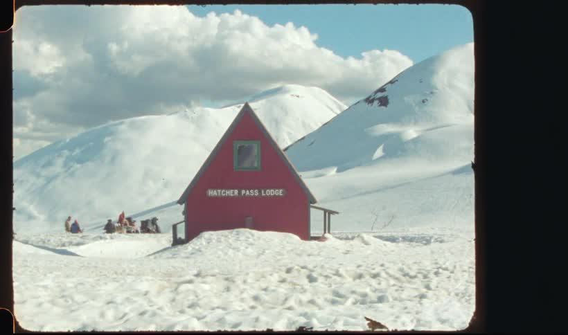 A red lodge on the mountains surrounded by snow