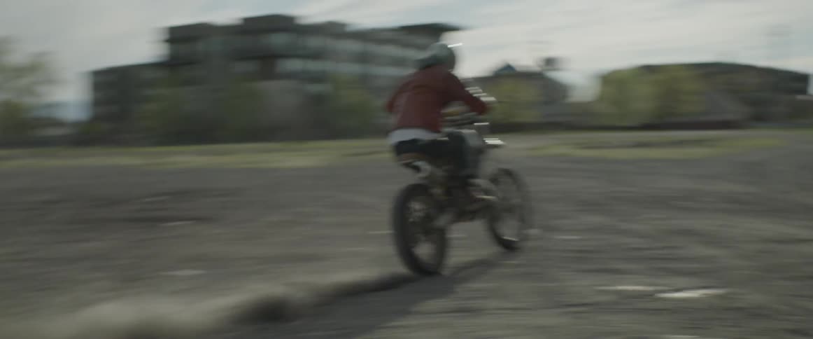 Person on a dirt bike rides in open area