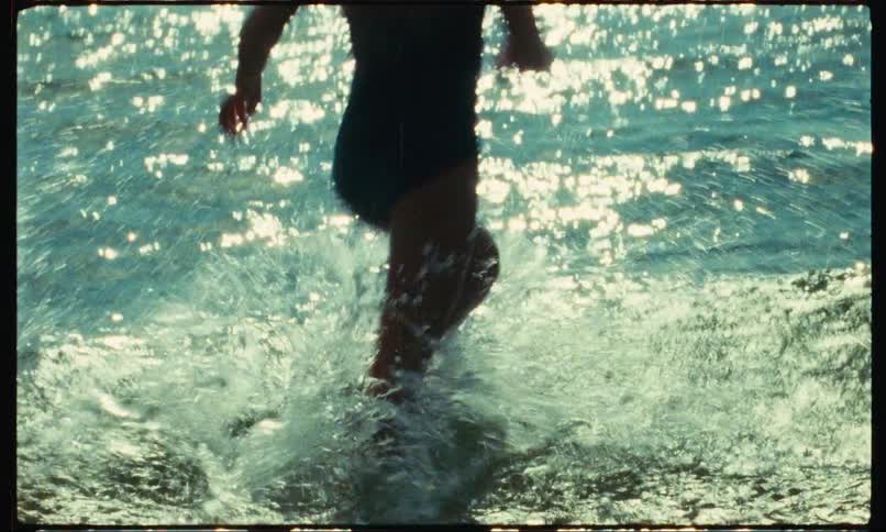 Girl running in the midst of the sea on a sunny day